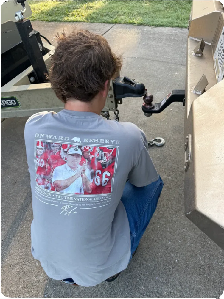 Lawson Gregory checking the dump trailer hitch in the driveway